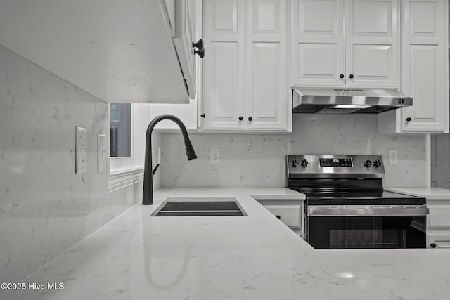 kitchen with white cabinets, sink, light stone countertops, and stainless steel range with electric cooktop