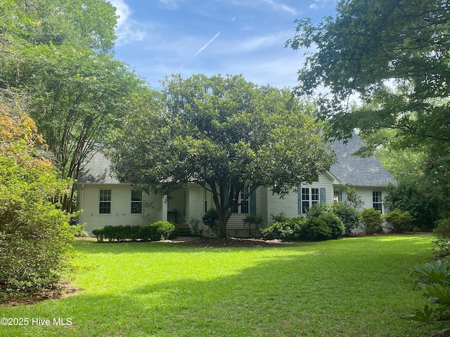 view of front of property featuring roof with shingles, brick siding, and a front lawn