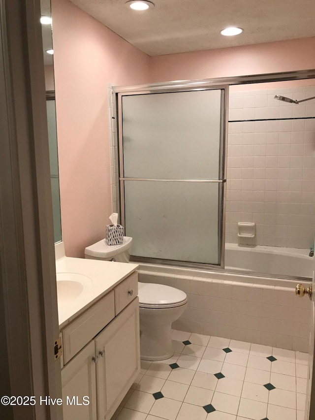 full bathroom with tile patterned floors, toilet, vanity, and combined bath / shower with glass door