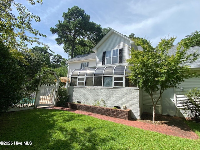 back of house featuring a sunroom and a yard