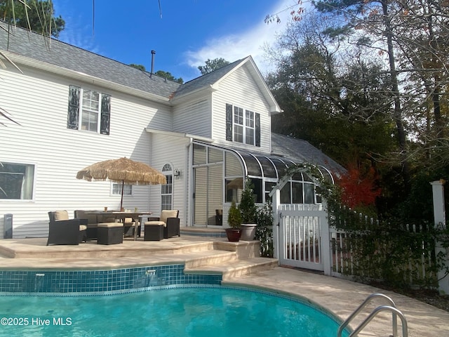 rear view of house featuring a patio area, an outdoor living space, and a sunroom