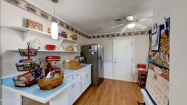 kitchen featuring stainless steel fridge, ceiling fan, pendant lighting, white cabinets, and light hardwood / wood-style floors