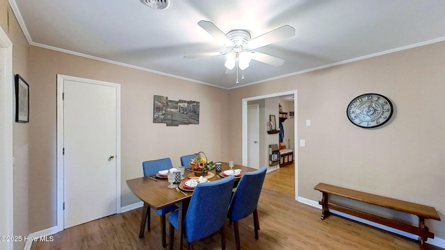 dining room featuring ceiling fan, light wood-type flooring, and ornamental molding