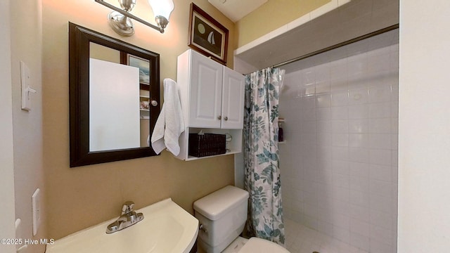 bathroom featuring a shower with curtain, sink, and toilet