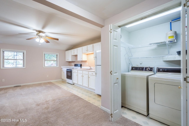 clothes washing area featuring ceiling fan, washer and clothes dryer, light colored carpet, and sink