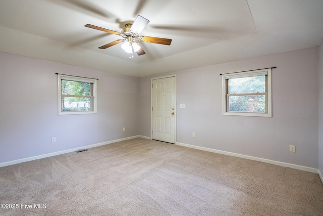 carpeted empty room featuring ceiling fan and a wealth of natural light