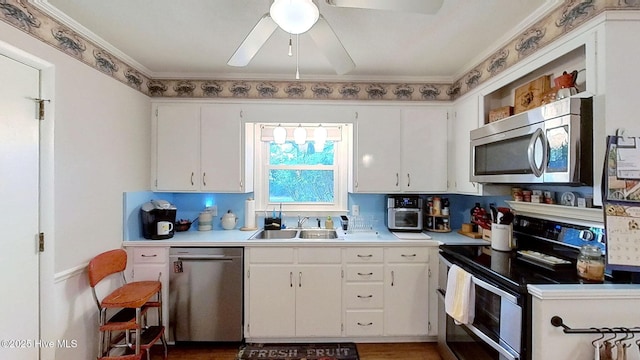 kitchen with backsplash, white cabinets, sink, ceiling fan, and appliances with stainless steel finishes