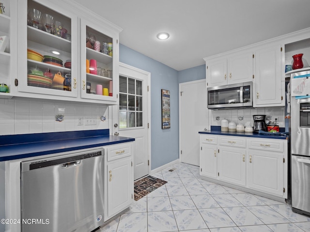 kitchen with backsplash, white cabinetry, and appliances with stainless steel finishes