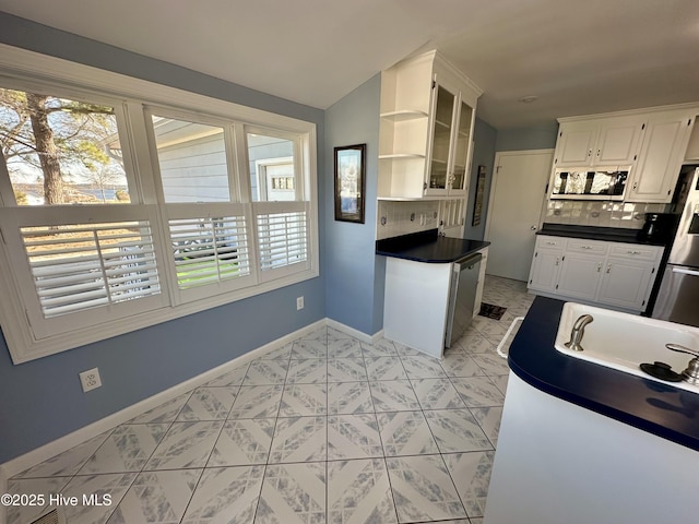 kitchen with tasteful backsplash, plenty of natural light, white cabinets, and vaulted ceiling