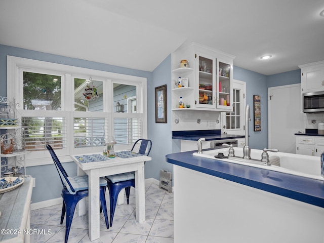 kitchen featuring white cabinetry and sink