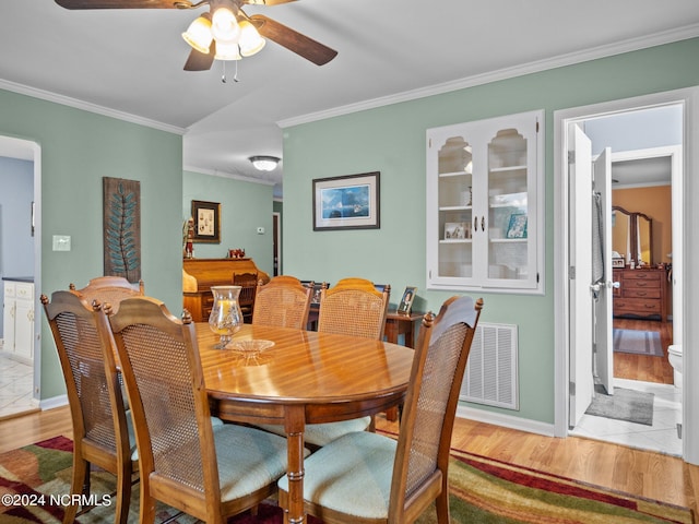 dining area featuring light wood-type flooring, ceiling fan, and ornamental molding