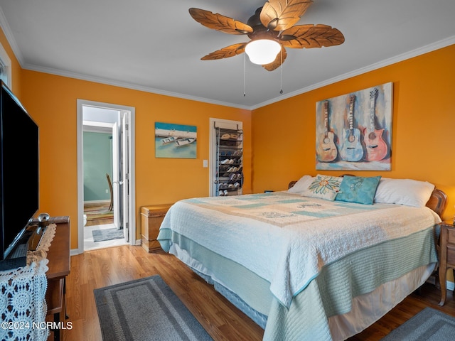 bedroom with ceiling fan, wood-type flooring, ornamental molding, and connected bathroom