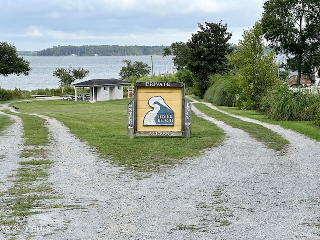 view of property's community with a water view and a lawn