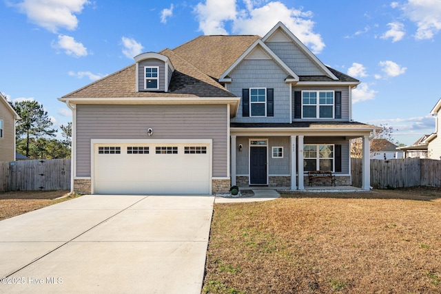 craftsman inspired home featuring a porch, a front yard, and a garage