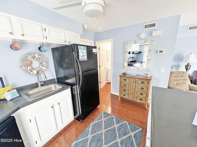 kitchen featuring dark countertops, black appliances, and white cabinetry