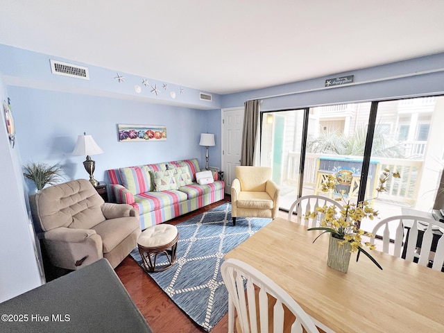 living area with visible vents and wood finished floors