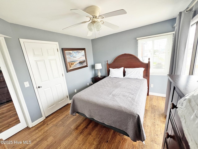 bedroom with wood finished floors, a ceiling fan, and baseboards