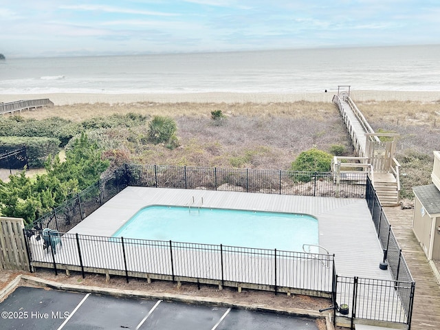 view of swimming pool with a fenced in pool, a patio area, a water view, and fence