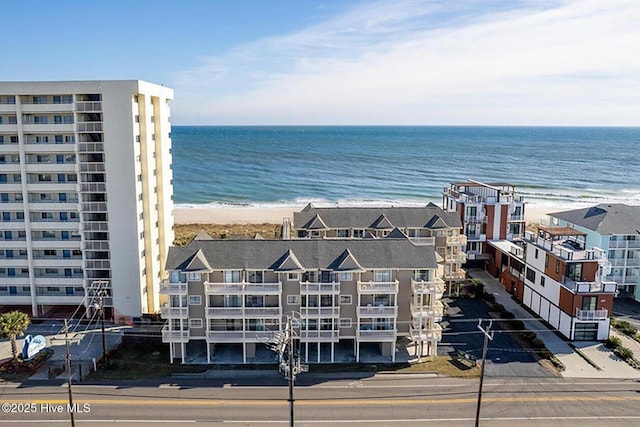 drone / aerial view with a water view and a beach view