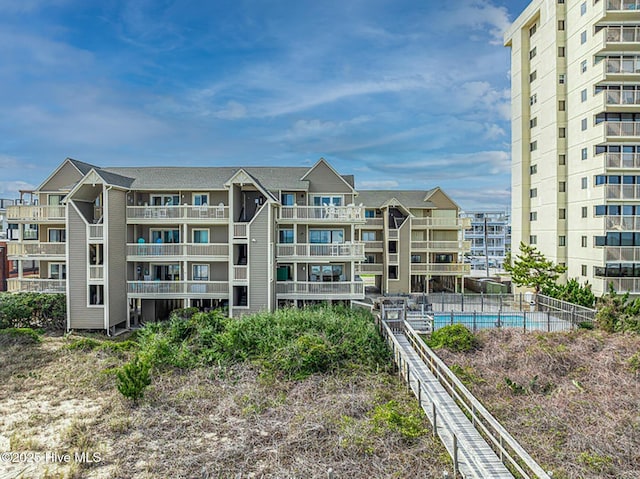 view of property with fence and a community pool