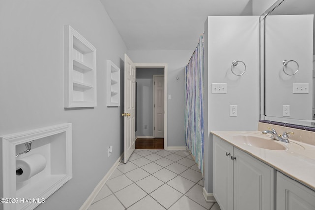 bathroom with built in shelves, tile patterned floors, and vanity