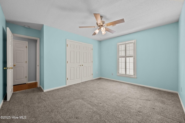 unfurnished bedroom with a textured ceiling, ceiling fan, a closet, and carpet floors