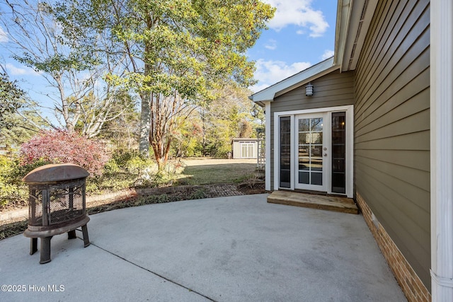 view of patio featuring an outdoor fire pit and a storage shed