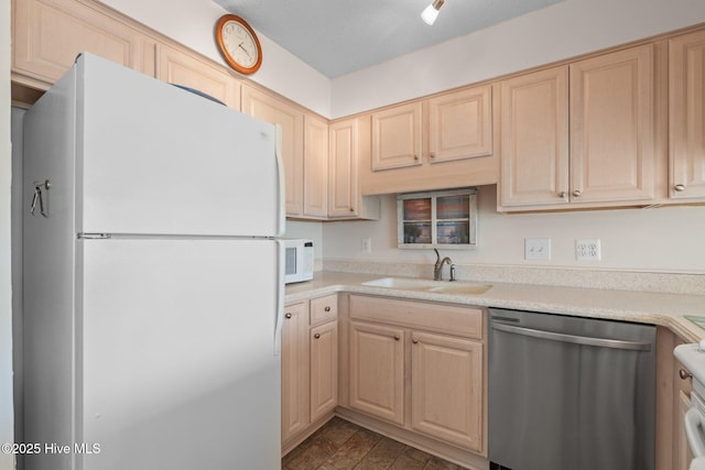 kitchen with a textured ceiling, white appliances, sink, and light brown cabinetry