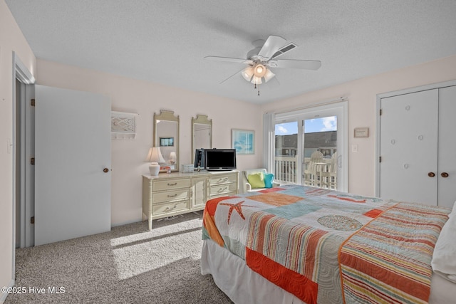 bedroom with access to exterior, a textured ceiling, light colored carpet, and ceiling fan