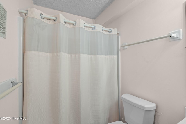 bathroom with toilet and a textured ceiling