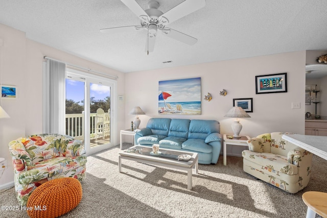 carpeted living room with ceiling fan and a textured ceiling