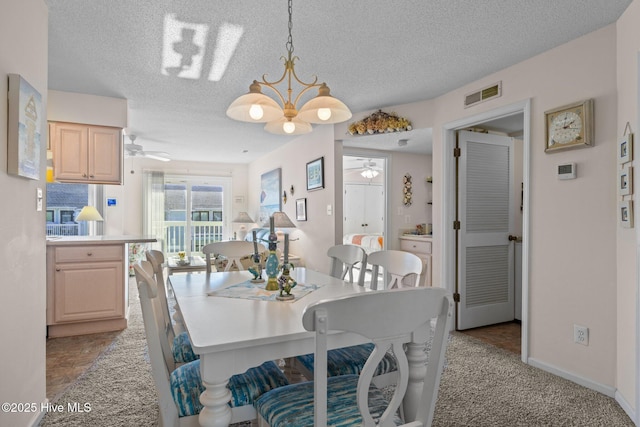 dining space featuring a textured ceiling, ceiling fan with notable chandelier, and light carpet