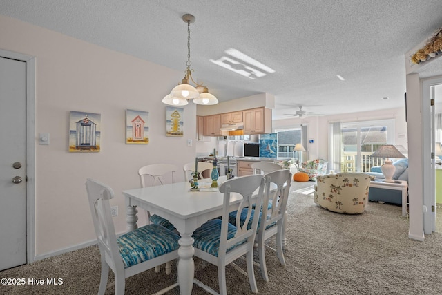 carpeted dining room featuring a textured ceiling and ceiling fan