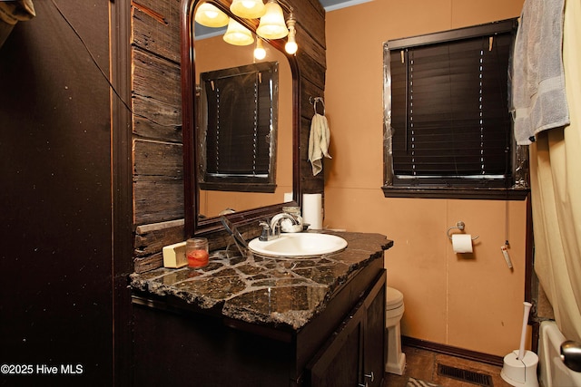 bathroom featuring vanity, radiator heating unit, and toilet