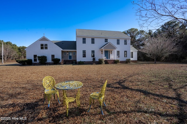 colonial-style house featuring a front yard