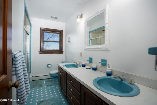 bathroom with a shower with door, vanity, a baseboard radiator, and toilet