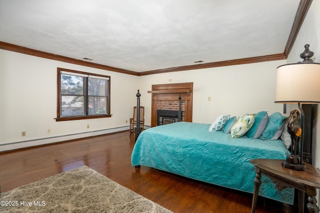 bedroom with a fireplace, ornamental molding, baseboard heating, and dark wood-type flooring