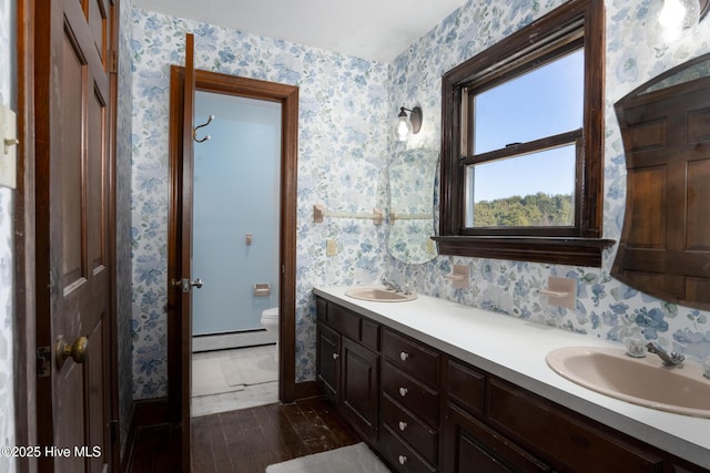 bathroom with hardwood / wood-style flooring, toilet, vanity, and a baseboard heating unit