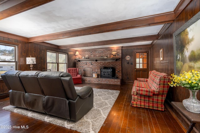 living room featuring beamed ceiling, dark hardwood / wood-style floors, wood walls, and a wood stove