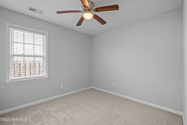 carpeted spare room with ceiling fan and plenty of natural light