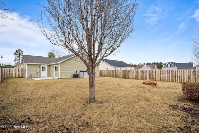 view of yard featuring a fire pit, central air condition unit, and a patio area