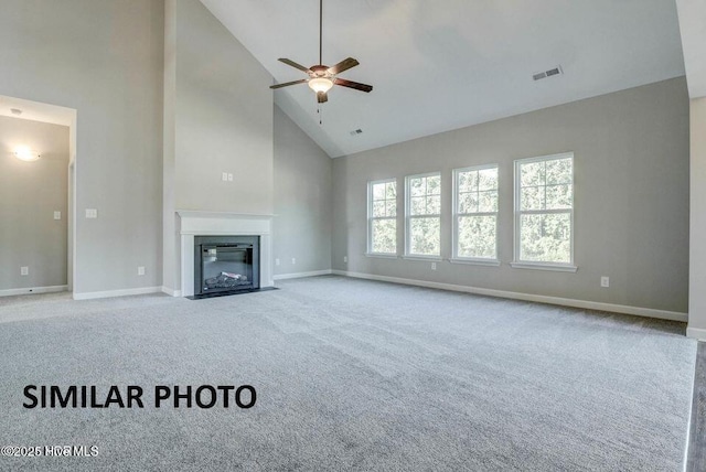 unfurnished living room with ceiling fan, high vaulted ceiling, and light carpet