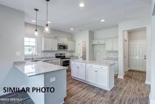 kitchen with white cabinetry, appliances with stainless steel finishes, sink, and decorative light fixtures