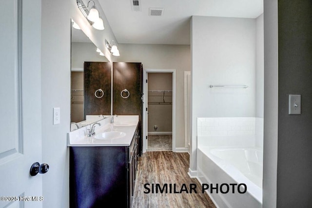 bathroom featuring vanity, a bathing tub, and wood-type flooring