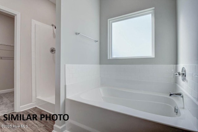 bathroom featuring shower with separate bathtub