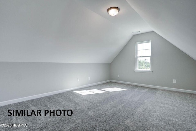additional living space featuring carpet floors and vaulted ceiling