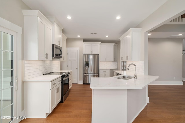 kitchen featuring white cabinetry, sink, hardwood / wood-style flooring, and stainless steel appliances