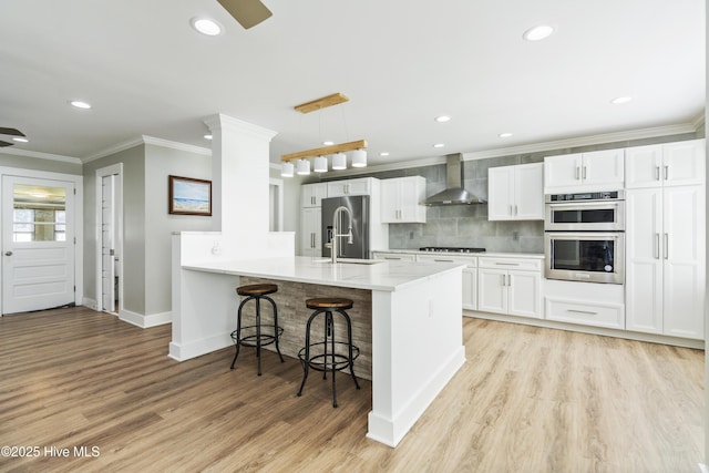 kitchen with ornamental molding, ceiling fan, sink, decorative light fixtures, and light hardwood / wood-style floors