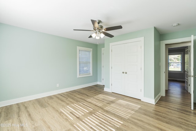 unfurnished bedroom featuring ceiling fan, a closet, and light hardwood / wood-style flooring