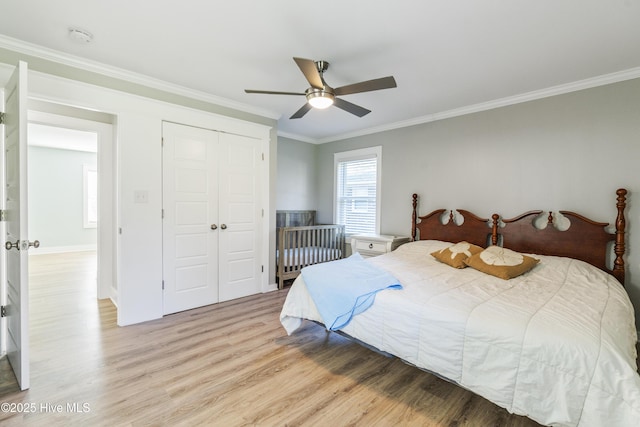 bedroom featuring ceiling fan, light wood-type flooring, ornamental molding, and a closet